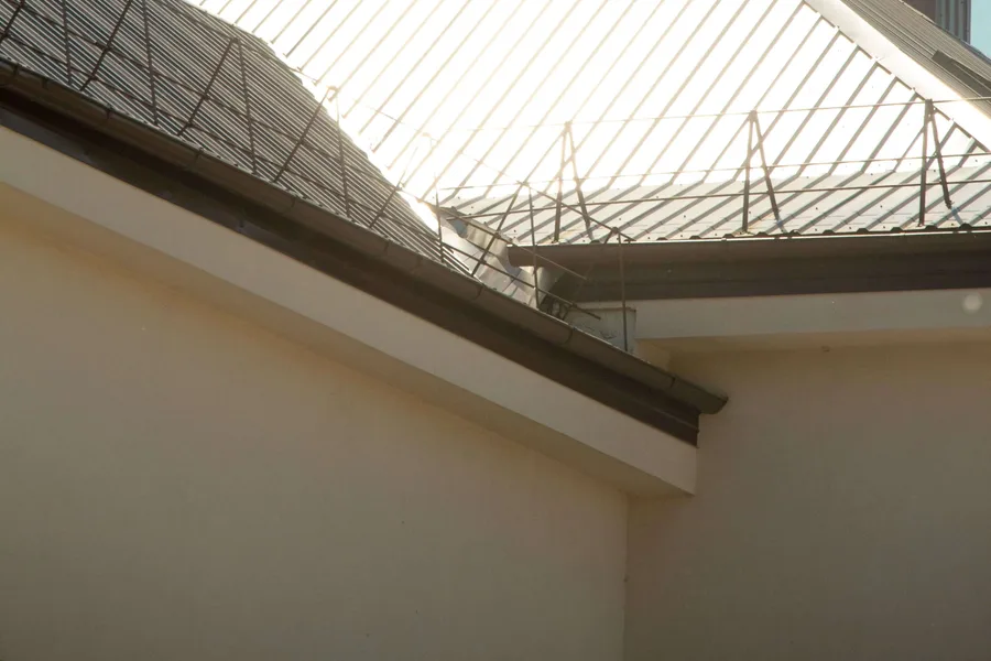 Light-colored standing-seam metal roof above a building