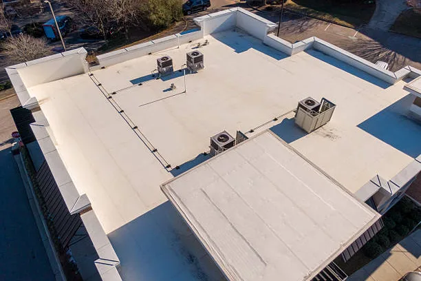 Light-colored commercial low-slope roof with rooftop equipment and parapets